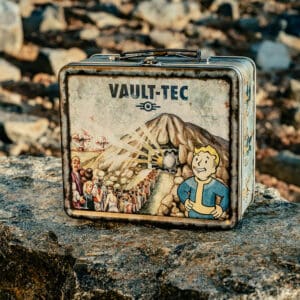 Weathered Vault Tec Lunchbox resting on a rock